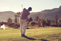 A golf player immediately after having hit the ball