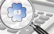 A calculator with a magnyifying glass showing the number 63