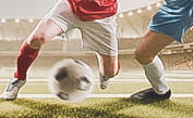 Two footballers batting for a football