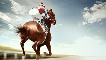 A jockey rides a horse around a dirt track.