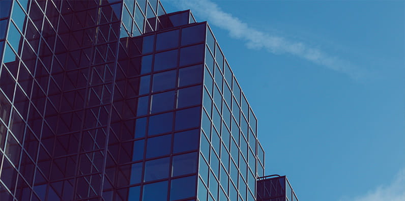 Sebuah blok kantor besar digambarkan dengan langit biru di latar belakang