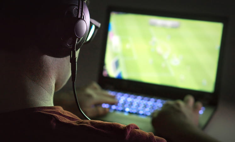 Seorang gamer menonton sepak bola di komputer mereka