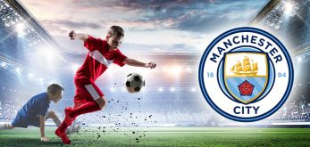 Children playing on a football field and the Manchester City logo.