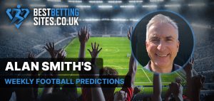 The image features Alan Smith, a football expert, with a stadium background filled with cheering fans. The text overlay reads "ALAN SMITH'S WEEKLY FOOTBALL PREDICTIONS" and is associated with the website "BESTBETTINGSITES.CO.UK." The image promotes his weekly football predictions. Alan Smith is shown smiling in the circular inset.