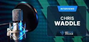 An illustration depicting a professional interview setting. The left side shows a high-quality studio microphone, set against a blurred background of soundproofing panels, suggesting a recording environment. On the right side, there is a text box labelled "Interviews" at the top, with the name "Chris Waddle" prominently displayed in the centre. Below this, there is the logo and URL for a betting website, "bestbettingsites.co.uk." The overall design combines a modern and clean aesthetic, highlighting the focus on sports betting interviews.